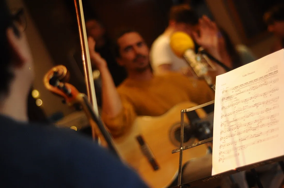Guitar, string player and score during the rehearsal